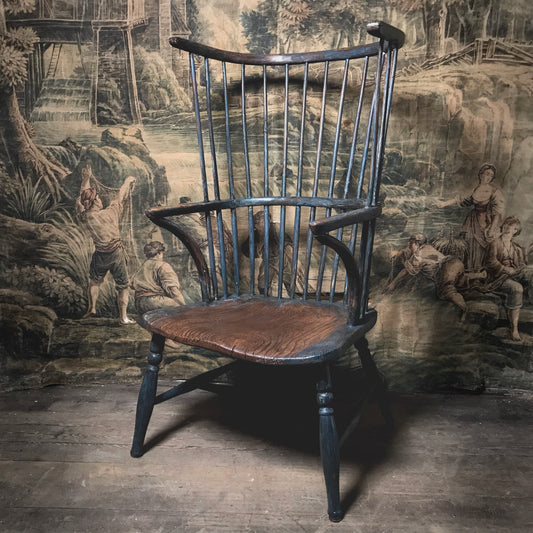 A comb-back Windsor armchair with a brown elm seat and a curved ash top rail, placed against a Leicestershire c.1800 backdrop.