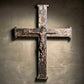 Medieval cross with a dark, weathered finish on a wooden surface.