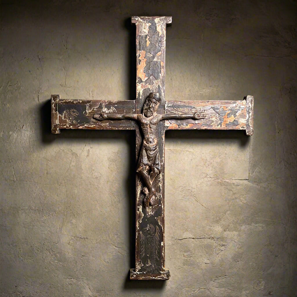 Medieval cross with a dark, weathered finish on a wooden surface.